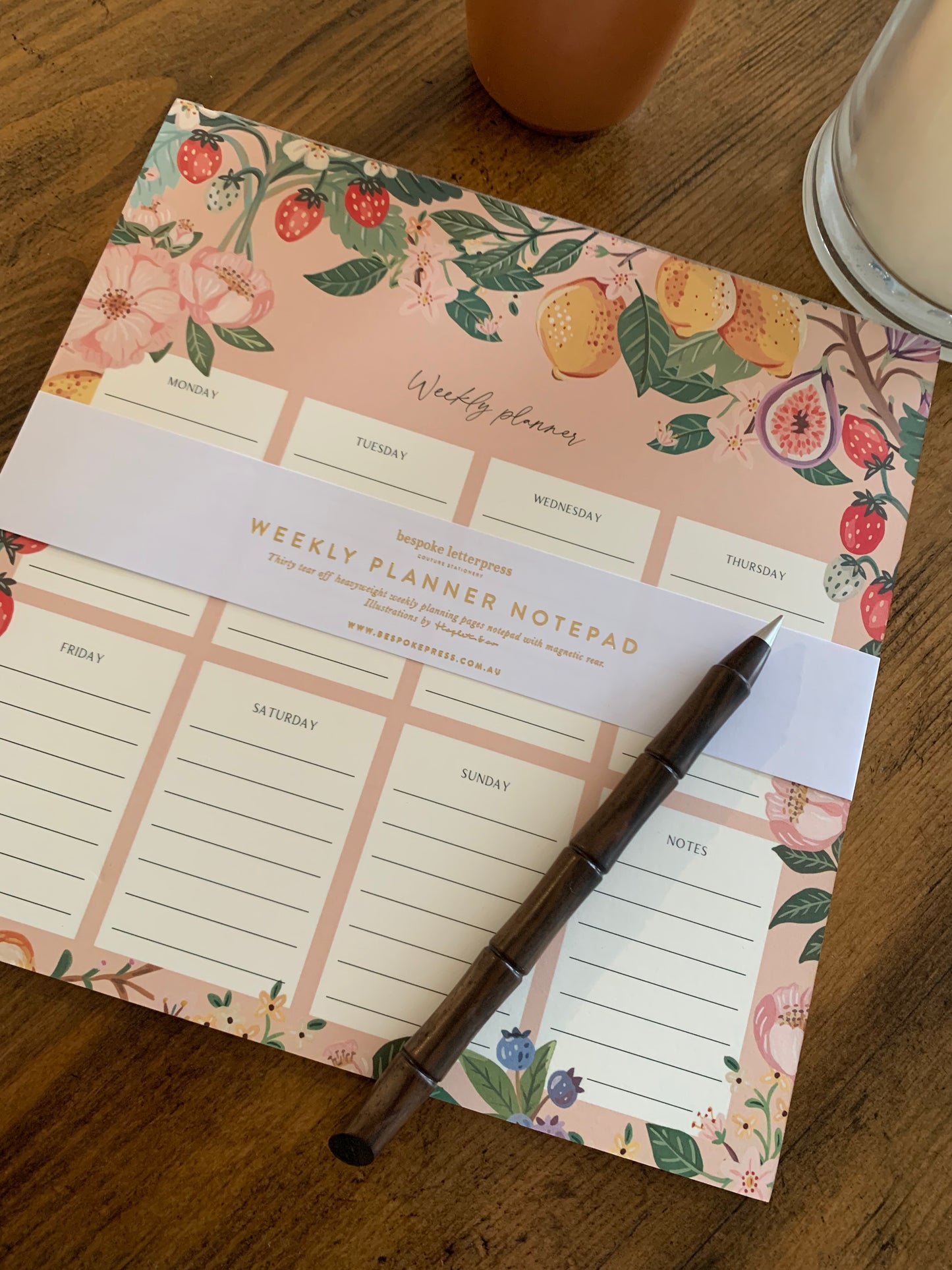 weekly planner notepad summer fruit lemons figs berries on pink floral background with pen