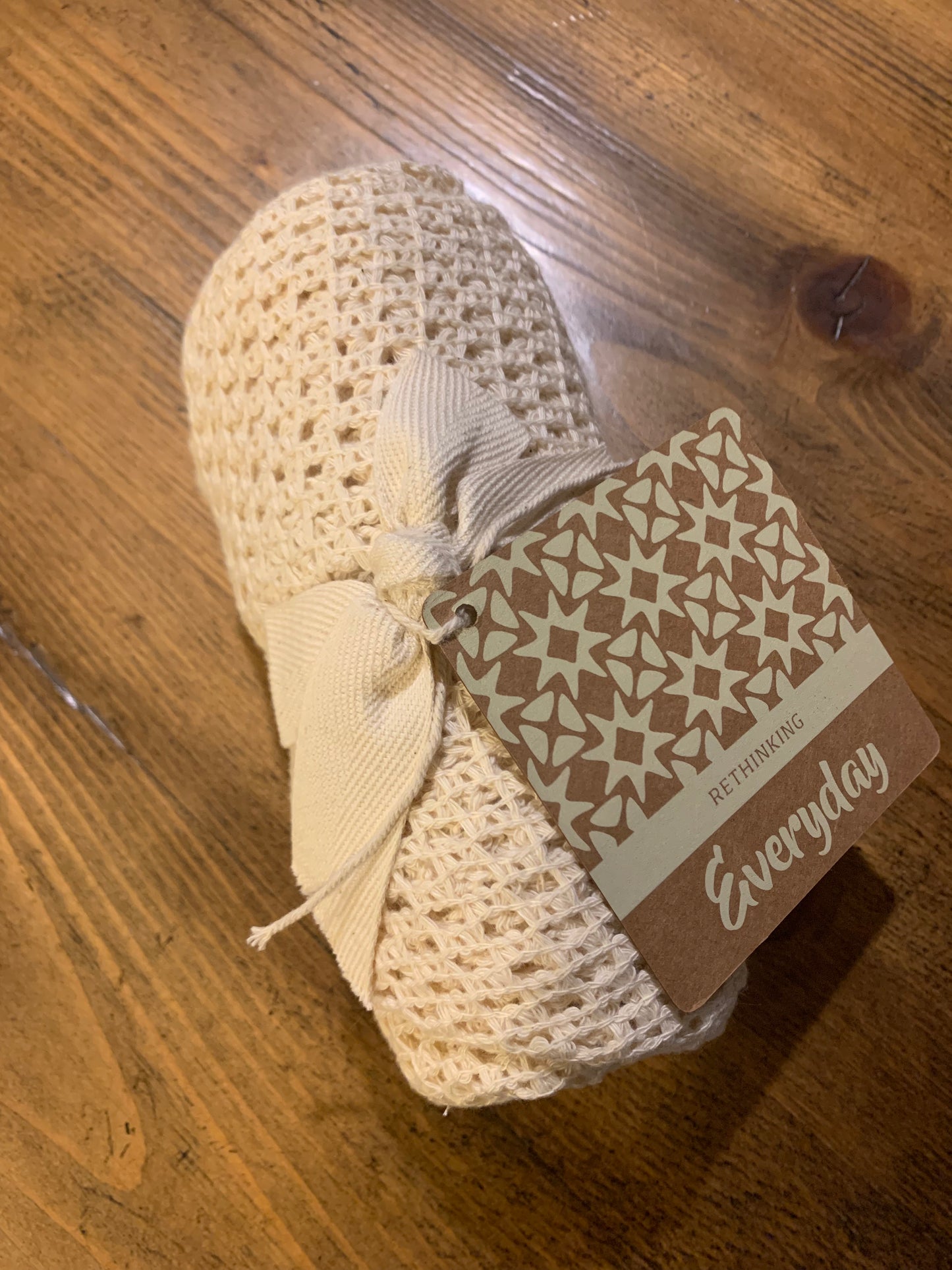 star net shopping bag rolled up and tied with cotton ribbon and brown paper product tag