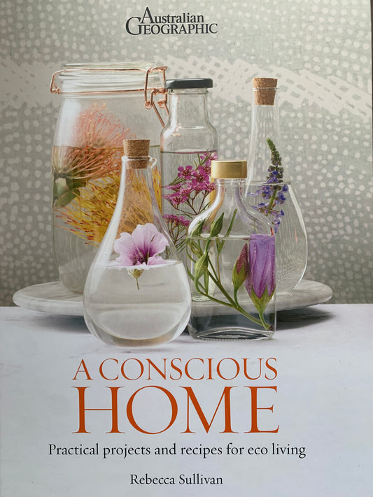 Cover photo of a conscious home practical project and recipes for eco living by Rebecca Sullivan. 5 Assorted clear jars & vessels filled with water & colourful native Australian  botanicals on a white marble surface & tray & grey & white spotted background.